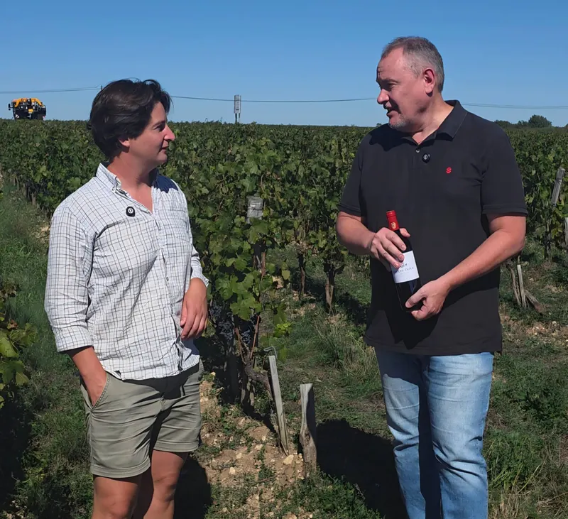 Clémence, do Château Doyac, e o fundador da Monduvin conversando entre as vinhas em Bordeaux, com uma garrafa do Château Doyac